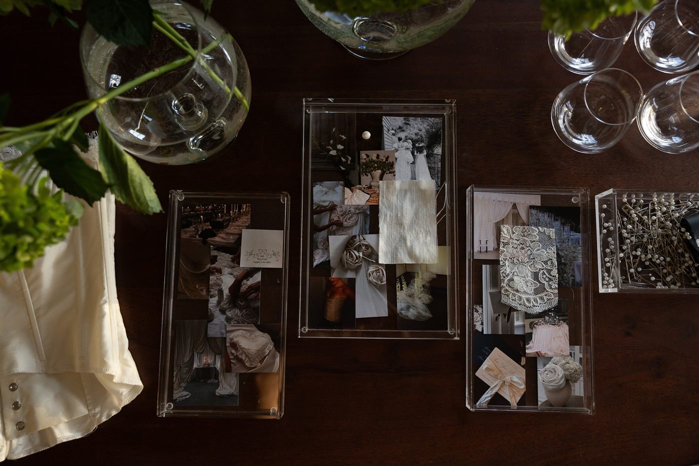 Design references and fabric swatches for the Montecito gown laid out in acrylic frames on a dark wood table.